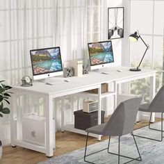 two computer monitors sitting on top of a white desk