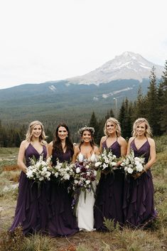 a group of women standing next to each other on top of a grass covered field