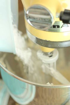 a yellow mixer is being used to make batter