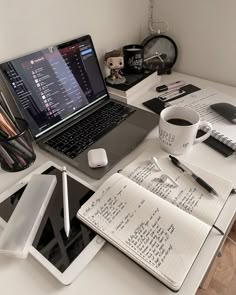 an open laptop computer sitting on top of a desk next to a cup of coffee