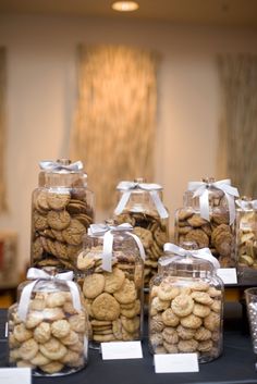 a table topped with lots of cookies and jars filled with them on top of each other