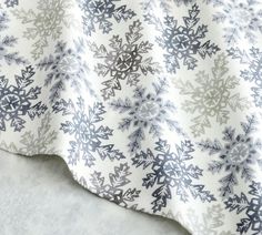 a white and blue blanket with snowflakes on it