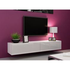 a white entertainment center with a large flat screen tv mounted on it's side