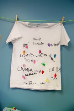 a t - shirt that has been hung on a clothes line with the names of friends