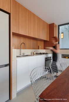 a blurry photo of a person in a kitchen next to a table with chairs