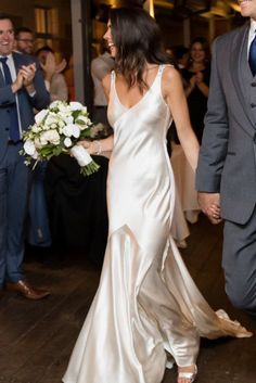 a bride and groom walking down the dance floor