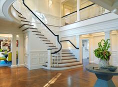 a large white staircase in a house with wood floors