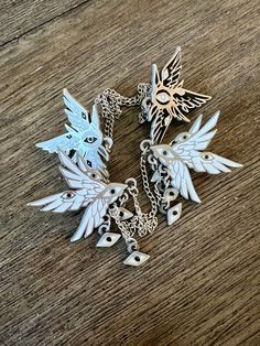 "ANGELUS ANTIQUA -- Antique SILVER enamel pin set  Black and white enamel pins, with antique silver plating SPECS: \"WATCHER\" - Linked pins (1.5'' wide) with hanging eyes (.5'' each). Chain measures 4.5'' \"SERAPH\" - Linked pins (1.8'' tall) with two uneven chains (4.5'' and 5'')" Enamel Pins Aesthetic, Angel Pins, Collar Pins, Cool Pins, Funky Jewelry, Fantasy Jewelry, Cute Pins, Dream Jewelry, Silver Enamel