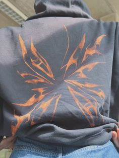 a person wearing a hoodie with an orange and black design on it's back