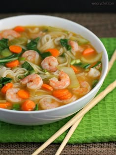 a bowl of shrimp noodle soup with chopsticks