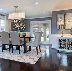 a dining room table with chairs and rug in front of the window, next to a fireplace