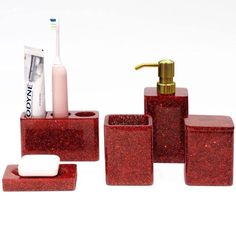 red bathroom accessories set with toothbrush holder and soap dispenser on white background