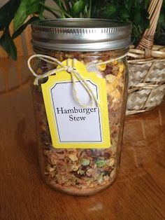 a jar filled with food sitting on top of a wooden table next to a potted plant