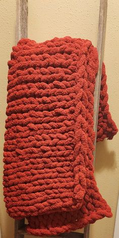 a red blanket sitting on top of a wooden chair