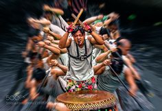 a group of people with drums and sticks in their hands, all holding on to each other