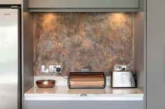 a metallic refrigerator freezer sitting inside of a kitchen next to a white counter top