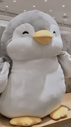 a large stuffed penguin sitting on top of a shelf