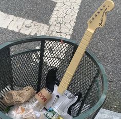 an electric guitar sitting in a trash can