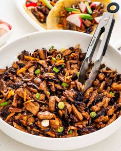 a white bowl filled with meat and veggies