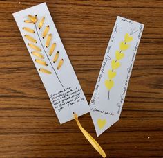 two pieces of paper with yellow flowers on them sitting on a wooden table next to each other