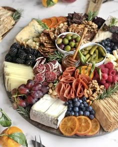 a platter filled with cheese, fruit and crackers