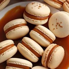 several macaroons are sitting on a plate covered in caramel and white icing