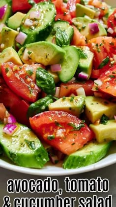 a salad with tomatoes, cucumber and red onion on it in a white bowl