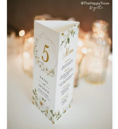 the table numbers are placed on top of an empty card box for guests to use