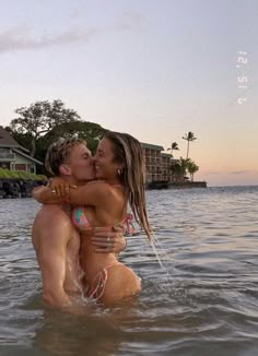 two people in the water kissing each other