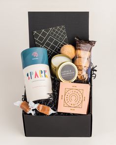 a black box filled with different types of food and drinks on top of a table