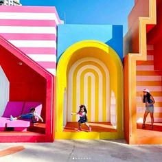 two people are standing in front of colorful structures that look like they have been built into the