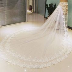 a bride's wedding dress is shown in front of a mirror with her veil pulled back