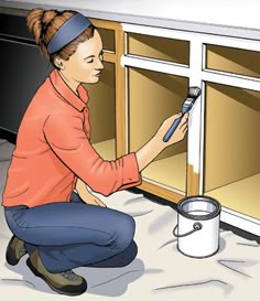 a woman is painting the inside of a cabinet