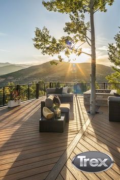 an outdoor deck with furniture and trees in the background