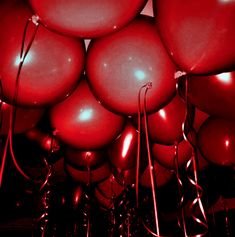 many red balloons are floating in the air