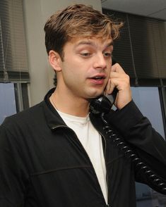 a young man is talking on the phone