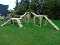 a wooden play set in the middle of a grassy area with stairs leading up to it