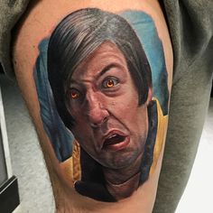 a close up of a person with a surprised look on his face and arm tattoo