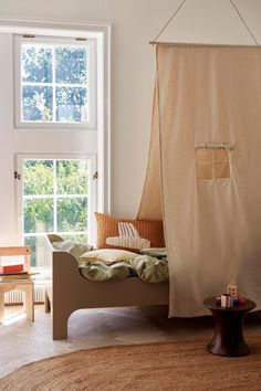 a bedroom with a canopy bed in the corner and a rug on the floor next to it