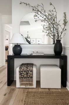 a black and white console table with two vases on it