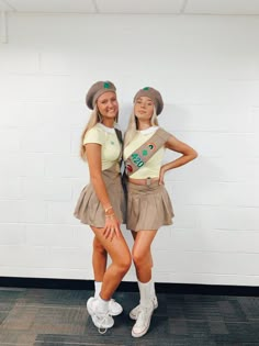 two young women posing for the camera in front of a white wall wearing matching outfits