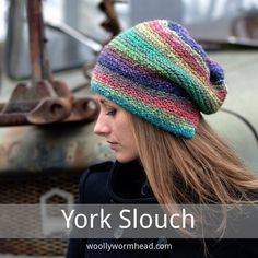 a woman with long hair wearing a multicolored knitted slouch hat