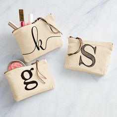 A girl can never have too many bags! From traveling, to tossing in a purse or gym bag, this canvas cosmetic pouch is perfect for keeping items organized and secure each day. This cosmetic bag features a zip top closure with genuine leather pull and a printed initial exterior. | Mud Pie Initial H Canvas Cosmetic Pouch In White Initial Canvas, Diy Bag Designs, Local Gifts, Embroidered Bag, Grad Gifts, Mud Pie, Cosmetic Pouch, Leather Pulls