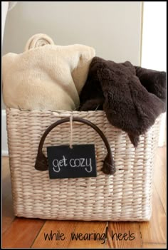 a wicker basket filled with clothes and a sign that says get cozy while wearing heels