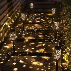 some lights that are on the steps in the night time light up the walkway with their shadows