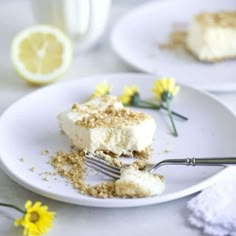 there is a piece of cake on the plate with a fork and some flowers next to it