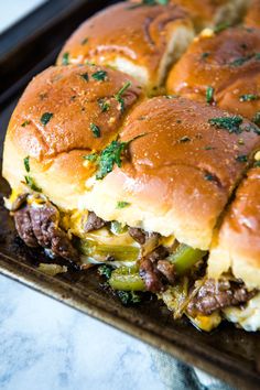 a cheeseburger with meat and vegetables on a baking sheet, ready to be eaten