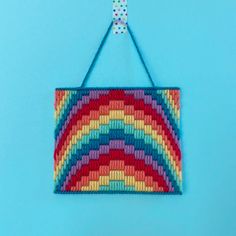 a multicolored bag hanging from a hook on a blue background with polka dots