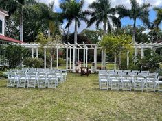 an outdoor ceremony setup with white chairs