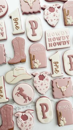 pink and white decorated cookies with horse, cowboy boots, heart, horseshoes, letter p